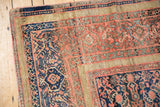 Antique Farahan rug corner with blush red henna motifs, navy lattice, and aged wear.