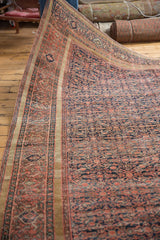Antique Farahan rug's intricate henna plant motif in blush brick red, navy blue, and dusty gold.