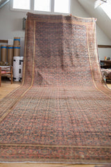 Antique Farahan runner's intricate henna plant motif in aged brick red and gold border detail.