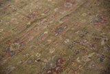 Antique Mahal rug's moss green field, featuring oversized palmettes, floral motifs, and low pile.