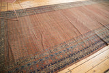 Angled view of antique Malayer rug's dusty brick red Mir boteh field and multi-band borders.