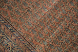 Mir boteh motifs in a dusty brick red field, contrasted by a navy and antique ivory border on this antique Malayer.