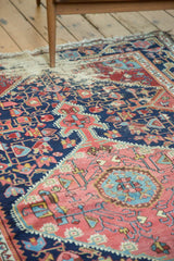 Distressed antique Josan Sarouk rug close-up showing exposed foundation, red and navy geometric vinery.