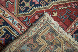 Distressed Josan Sarouk rug corner, revealing hand-knotted pile, geometric vinery, and tattered fringe.