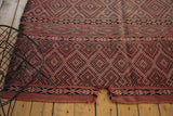 Vintage Moroccan Jijim carpet's tattered end with missing area, in dusty rose and charcoal geometric patterns.