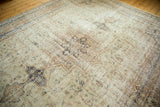 Distressed vintage Sparta carpet with faded ivory, navy blue, and brown medallion patterns and even wear.