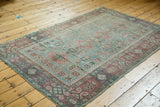 Distressed Sivas rug featuring softened sea foam green and faded raspberry pomegranate motifs.