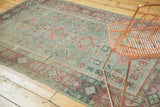 Distressed Sivas rug border and field with faded raspberry vines, oxidized green patterns.
