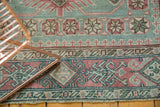 Vintage distressed Sivas rug border features angular geometric patterns in faded raspberry, oxidized copper green.