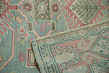 Distressed Sivas rug, faded teal, pink, beige pattern, even pile wear, hand-knotted reverse.