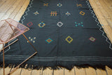 Vintage Moroccan Kilim detail: black fringe, white woven lines, and colorful embroidered diamonds.