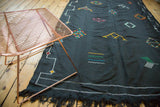 Black Kilim displaying bright geometric agricultural motifs and fringe detail.