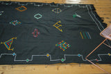 Black Moroccan Kilim with colorful geometric diamonds, wavy patterns, and stepped border.