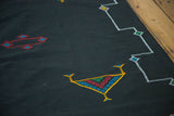 Hand-woven jet black Kilim with geometric plant motif and stepped white border.