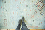 Embroidered geometric diamonds and pinwheels on a hand woven pale blue Moroccan Kilim.