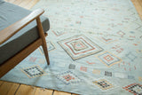 Serrated geometric diamonds, pinwheels, and lattice motifs on a powder blue Moroccan Kilim rug.