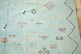 Playful geometric shapes and a wavy border on a pale powder blue Moroccan Kilim.