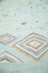 Close-up of Moroccan Kilim carpet's embroidered serrated diamonds in pale blue and terra cotta.