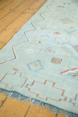 Pale blue Moroccan Kilim rug fringe and serrated geometric patterns.