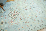 Pale blue Moroccan Kilim with diverse geometric patterns, serrated diamonds, and pinwheels.