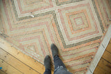 Distressed vintage Jijim carpet with concentric design in muted orange, beige, black, and patch.