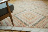 Distressed vintage Turkish Jijim carpet's kilim end, with geometric ivory and orange patterns.