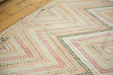 Angled view of distressed vintage Jijim carpet with faded geometric barber pole stripes.
