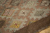 Hand-woven Turkish Jijim rug's secure coffee brown border with geometric diamond patterns.