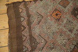 Geometric diamond patterns with blush, tangerine, and brown hues on a vintage Jijim rug.