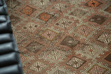 Vintage hand-woven Jijim rug with geometric diamond pattern in brown, ivory, blush, tangerine.