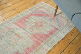 Vintage distressed Oushak runner with heavy abrashes, featuring blush, ivory, and seafoam blue.