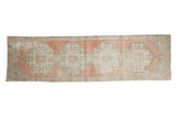 Distressed vintage Oushak runner with blush, ivory, and soft blue quadruple medallions, 2'6