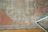 Distressed vintage Oushak rug pile texture showing soft blush, ivory and visible foundation.
