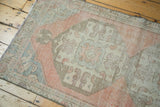 Distressed vintage Oushak runner pile featuring blush, ivory, and sea foam blue motifs.