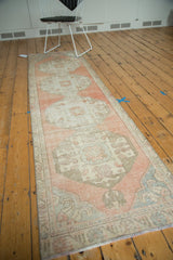Distressed Oushak runner's corner, featuring blush, ivory, and beige tones with visible foundation.