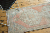 Faded blush, ivory, and blue curvilinear patterns on a distressed vintage Oushak rug.