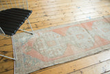 Worn texture of the vintage Oushak runner, revealing blush, ivory, and sea foam blue patterns.