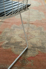 Distressed vintage Oushak runner with softened cinnabar red and beige medallion pattern.