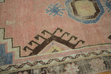 Vintage distressed Oushak rug with salmon, brown geometric patterns, pale blue, and worn pile texture.