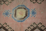 Distressed blush field texture showing geometric medallion and blue star motifs.