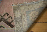 Distressed blush pile and hand-knotted beige foundation of the vintage Oushak rug.