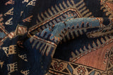 Folded vintage Kurdish runner, hand-knotted pile showing indigo, teal, and geometric animal motifs.