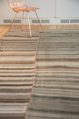Hand-stitched seam on a vintage Moroccan Kilim patchwork rug with neutral striped bands.