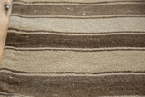Hand woven Moroccan Kilim patchwork showing textured horizontal bands of antique ivory and coffee brown.