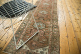 Distressed Malayer runner corner, showing copper, blush, and teal lotus motifs with even wear.