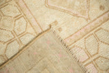 Distressed pile texture and hand-knotted foundation of a vintage Oushak rug in faded pink tones.