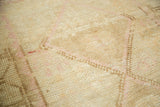 Close-up of distressed Oushak rug pile, showing even wear and faded ivory, sand, blush.