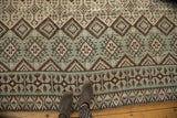 Geometric diamond and plant motifs on vintage Moroccan Kilim in brown, mint, and ivory.