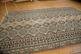 Moroccan Kilim displaying geometric diamond, gul, and plant motifs in mint, brown, ivory.