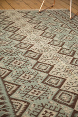 Close-up of vintage Kilim with dark brown, dusty mint green, ivory diamond, and gul motifs.